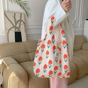 Borsa tote floreale in tela con fiori rossi e toppa LOVE portata da una modella