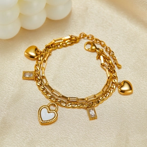 Double-layer golden heart bracelet with zircon charms and heart lock on satin background