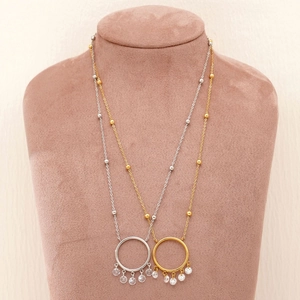 Gold and silver dreamcatcher necklaces with zircon pendants on brown velvet neck display