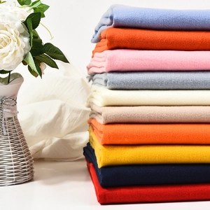 Thick cashmere-feel winter scarves stacked neatly in multiple colors like sky blue and pink