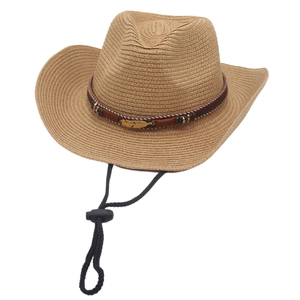 Detail of straw cowboy hat featuring metal feather ornament and adjustable wind cord