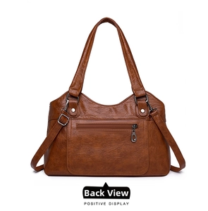 Détail d'un cabas vintage marron avec poche zippée fonctionnelle et finitions à rivets