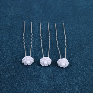 Detail of three white flower U-shaped hair pins for elegant bridal hairstyling