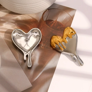 Detailed close-up of 18K gold and silver two-tone lava fluid heart-shaped stud earrings