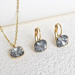 Detail of gold-plated stainless steel necklace and earrings set with square grey crystals