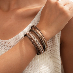 Détail d'un bracelet multi-rangs en cuir avec croix en cristal et texture alvéolée