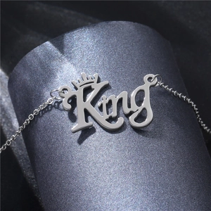 Collier pendentif King en acier inoxydable poli avec couronne sur fond sombre