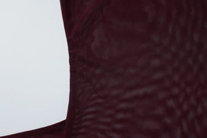 Gros plan sur la texture du tissu en maille bordeaux de cet ensemble robe moulante