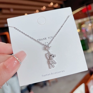 Detail shot of a silver bear pendant necklace encrusted with white zircon stones