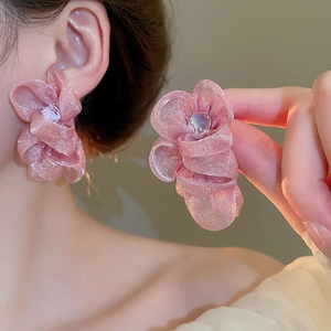 Close-up of pink chiffon flower stud earrings with delicate mesh petals and central crystal