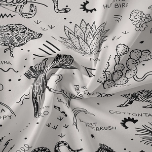 Close-up of soft fabric texture showing desert plants and animals printed pattern