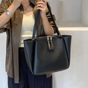 Minimalist black large capacity tote bag in soft leather shown on model for daily commute