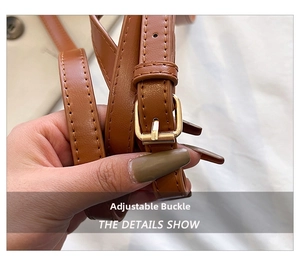 Detail of adjustable brown faux leather shoulder strap with gold-tone buckle hardware
