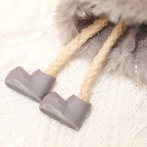 Detail of plush Christmas gift bag showing beige drawstring and gray cord locks
