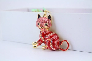 Macro view of a gold lucky cat keychain with sparkling red and pink rhinestones