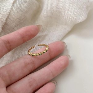 Macro shot of 925 silver gold-plated ring with six marquise green gemstones on finger