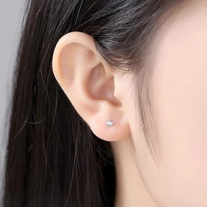 Macro shot of S999 sterling silver stud earring with zircon on a model earlobe