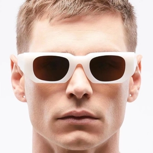 Close-up of modern white thick frame sunglasses with dark lenses on a model