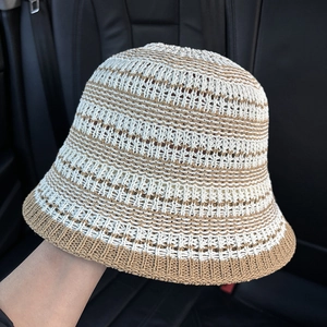 Detail of crochet knit bucket hat showing beige and khaki striped openwork texture