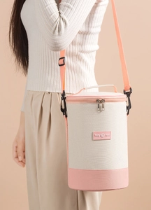 Close-up of insulated cylindrical lunch bag with adjustable shoulder strap and Tasty Food tag