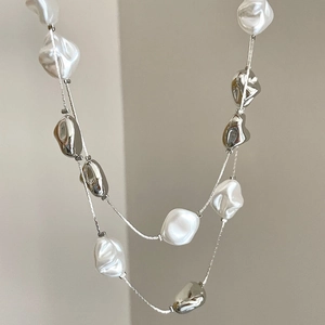 Detail of double-layer necklace with white irregular pearls and silver metallic beads