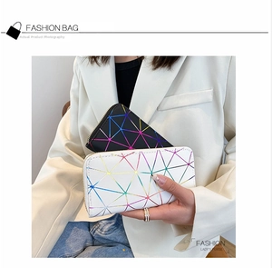 Detailed view of geometric patchwork long wallets with silver zippers in black and white