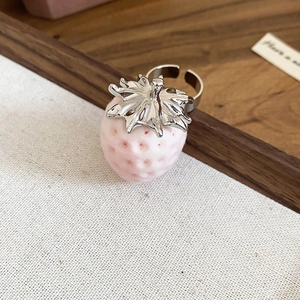 Detailed top view of a pink flocked strawberry ring with an adjustable silver band