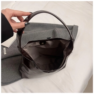 Detail view of large tote bag interior with magnetic closure and dark glossy finish