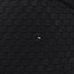 Macro view of black waffle knit fabric texture and embroidered ventilation eyelet detail