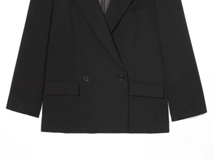 Gros plan du blazer noir croisé avec texture raffinée et détails de poches à rabat