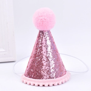 Close-up of pink sequined pet birthday hat with pom pom and elastic strap detail