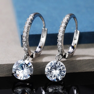 Macro shot of silver drop earrings with round cubic zirconia in four-prong setting