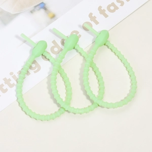 Detail of light green silicone cable ties with notched design and buckle head
