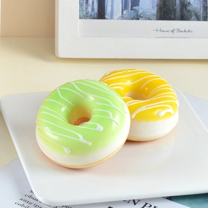 Set of two realistic PU donut magnets in mint green and lemon yellow on a white plate