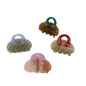 Set of four colorful acetate handbag-shaped hair claws with unique numeric patterns