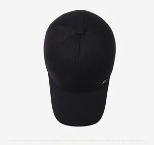 Top view of a black wool-like baseball cap with a classic six-panel design and metal logo