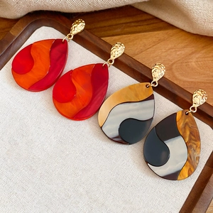 Ethnic teardrop earrings with marble resin pendants and gold hammered metal finish