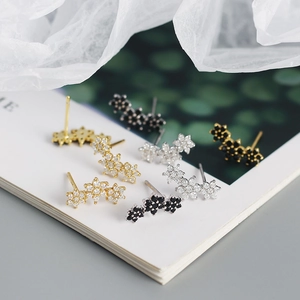 Detail view of s925 silver flower stud earrings with white and black zirconia in gold and silver