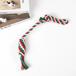 Macro detail of red, green and white braided cotton rope dog toy with ball and loop knots