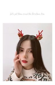 Detail of Christmas reindeer antler hair clip with red antlers and golden decorative balls