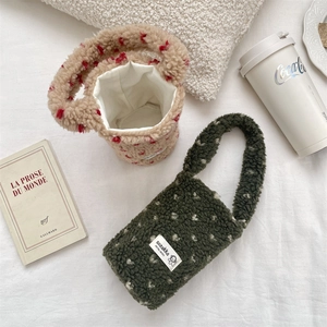 Macro shot of plush polka dot beverage bags in emerald and beige sherpa fleece material