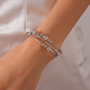 Macro shot of a layered silver metal bracelet with embedded crystals on female wrist