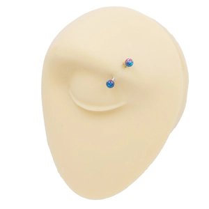 Detail of curved stainless steel eyebrow ring with blue pink glitter balls on model