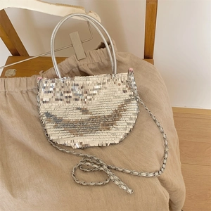 Detailed close-up of sparkling silver sequins and metal chain strap on a large canvas tote