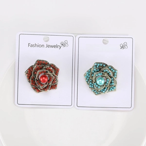 Detailed view of vintage rose brooches with turquoise and red beads and pearls