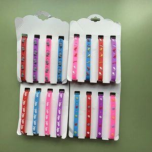 Flat lay of multiple silicone pet collars with bone and paw prints in various colors