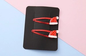Close-up of red glitter Christmas hat hair clips with resin star detail on display card