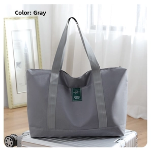 Detail of grey travel bag with durable handles placed on a silver suitcase
