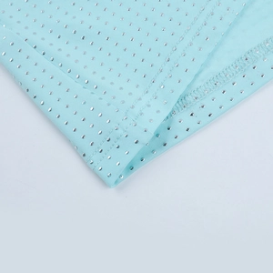 Close-up of light blue elastic fabric with sparkling silver sequins and fine stitching