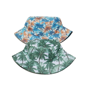 Detailed view of tropical coconut tree print on blue and green bucket hats for summer travel